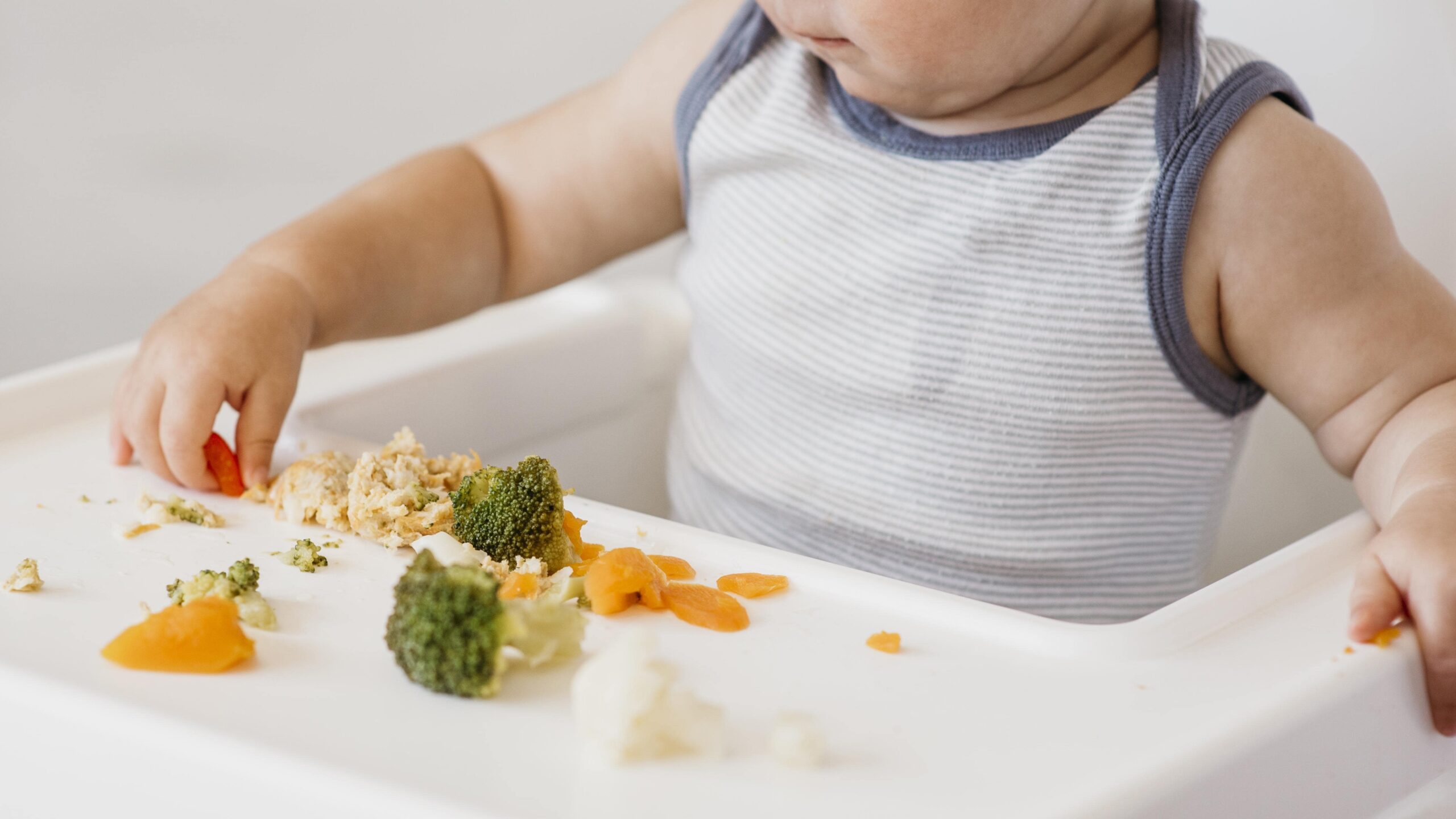 cute-baby-boy-highchair-choosing-what-eat-min cute-baby-boy-highchair-choosing-what-eat-min